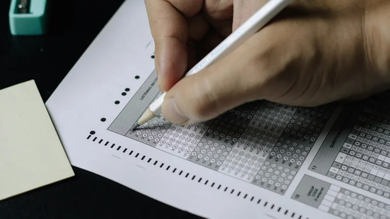 person filling out multiple choice on exam